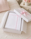 Carriage Boutique Julius Berger white knit baby blanket with pink satin ribbon trim inside a gift box