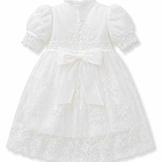 Carriage Boutique white lace christening gown with puffed sleeves, satin bow, and intricate embroidery back view.