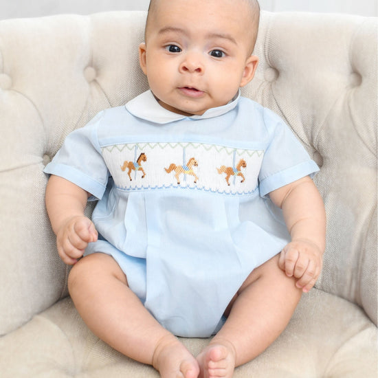 Carriage Boutique light blue smocked bubble romper with carousel horse embroidery and Peter Pan collar.