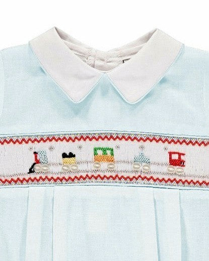 Carriage Boutique light blue baby romper with Peter Pan collar and smocked chest featuring a train motif in red, green, and yellow.