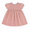 Carriage Boutique mauve baby dress with short sleeves, smocked yoke, and delicate floral embroidery on soft fabric.