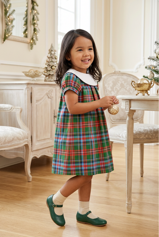 Carriage Boutique toddler girl wearing a multicolor plaid cotton dress with a white Peter Pan collar in a room