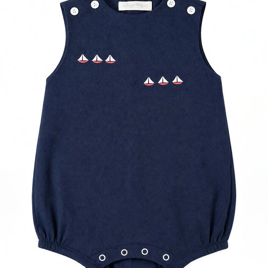 Carriage Boutique navy blue sleeveless bubble romper with embroidered sailboats and white button accents.