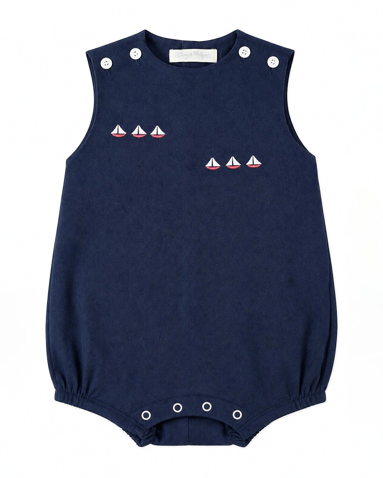 Carriage Boutique navy blue sleeveless bubble romper with embroidered sailboats and white button accents.