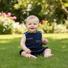 Carriage Boutique navy blue sleeveless bubble romper with embroidered sailboats for baby girls. Features shoulder buttons and snap closure.