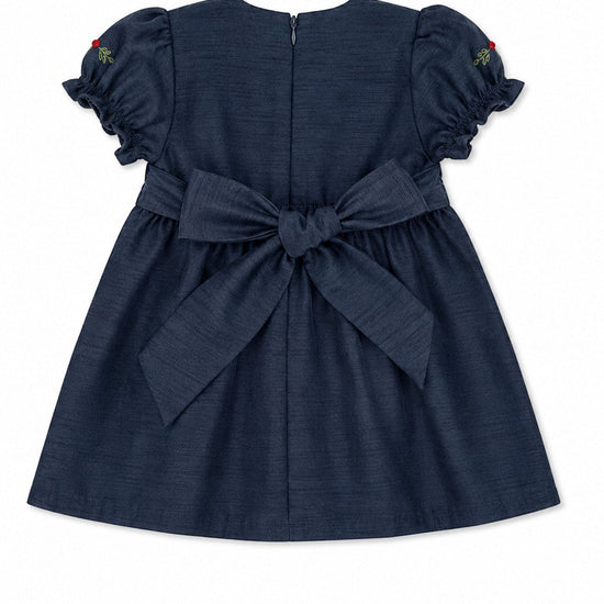 Carriage Boutique navy blue baby girl dress with a back bow, puffy sleeves, and zip closure, back view.