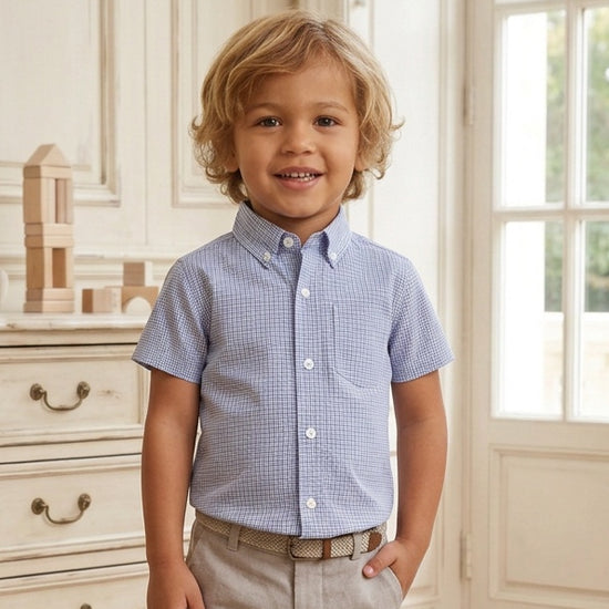 Carriage Boutique toddler boy wearing a navy blue check short-sleeve button-down shirt with khaki pants