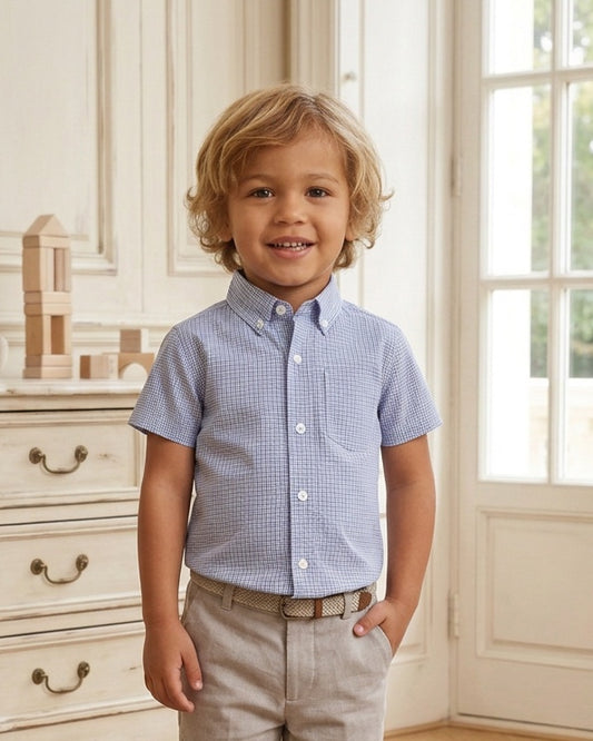 Carriage Boutique toddler boy wearing a navy blue check short-sleeve button-down shirt with khaki pants
