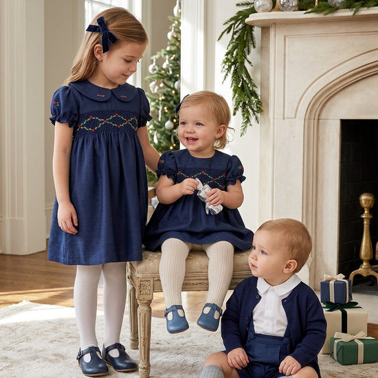 Carriage Boutique navy silk party dresses with smocked floral detail and puffy sleeves worn by two young girls