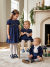 Carriage Boutique navy silk party dresses with smocked floral detail and puffy sleeves worn by two young girls