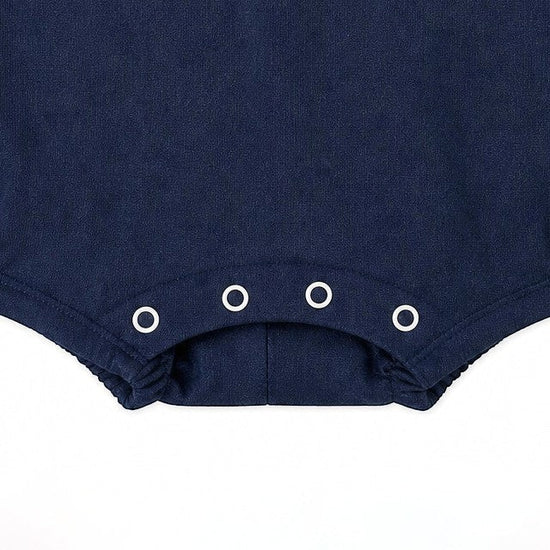 Carriage Boutique navy blue baby romper with sailboat embroidery and snap closure.