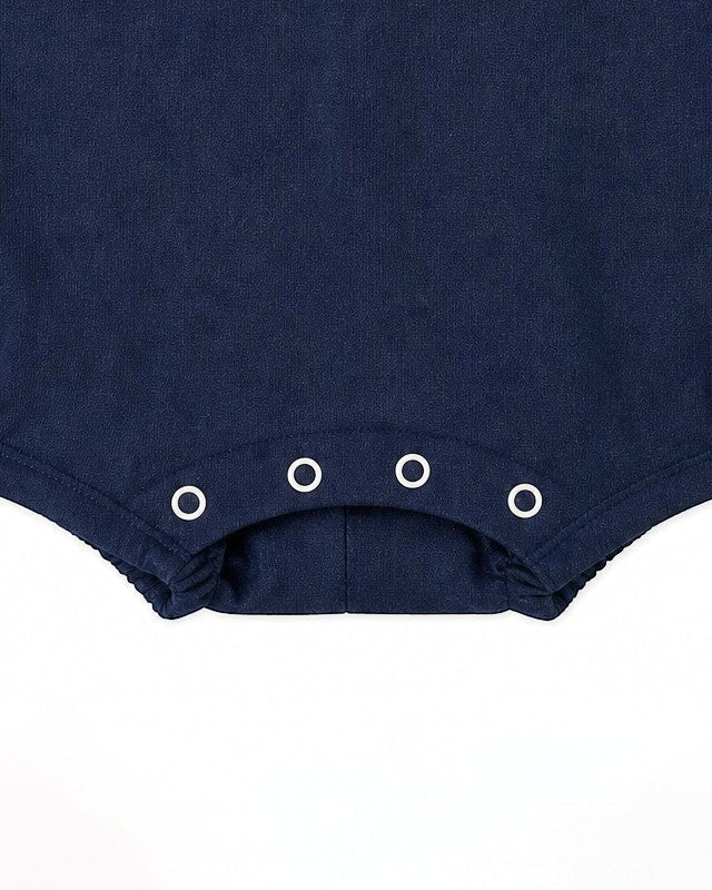 Carriage Boutique navy blue baby romper with sailboat embroidery and snap closure.
