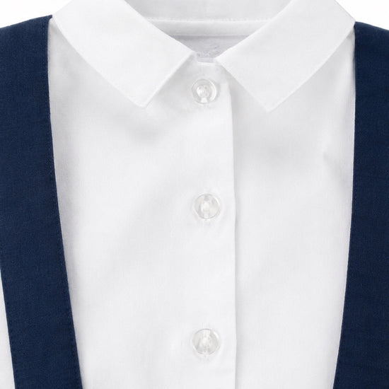 Carriage Boutique navy poly silk suspender shorts paired with a crisp white long-sleeve button-down shirt
