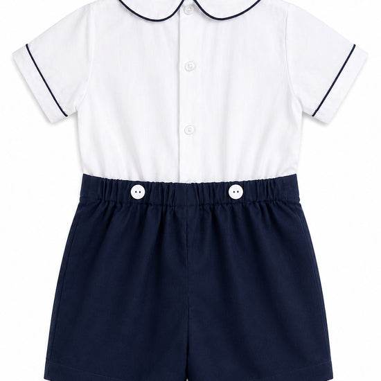 Carriage Boutique navy and white bobbie suit with Peter Pan collar, navy piping, and decorative buttons on shorts.