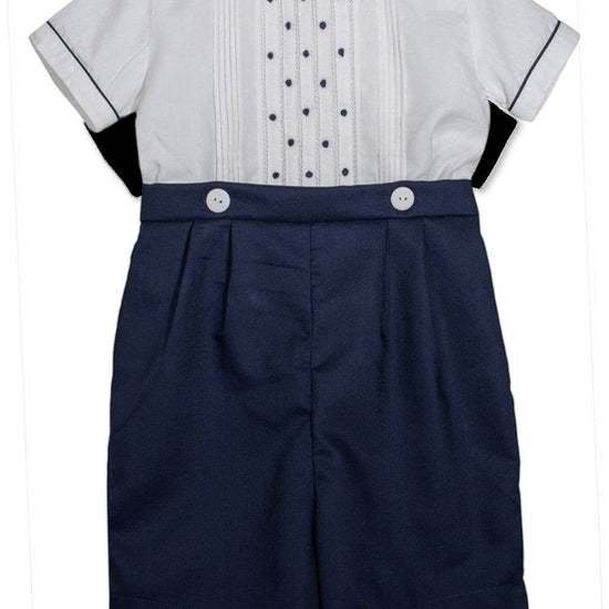 Carriage Boutique navy blue shorts with white buttons and a white short-sleeved shirt with pintucks and navy dots.