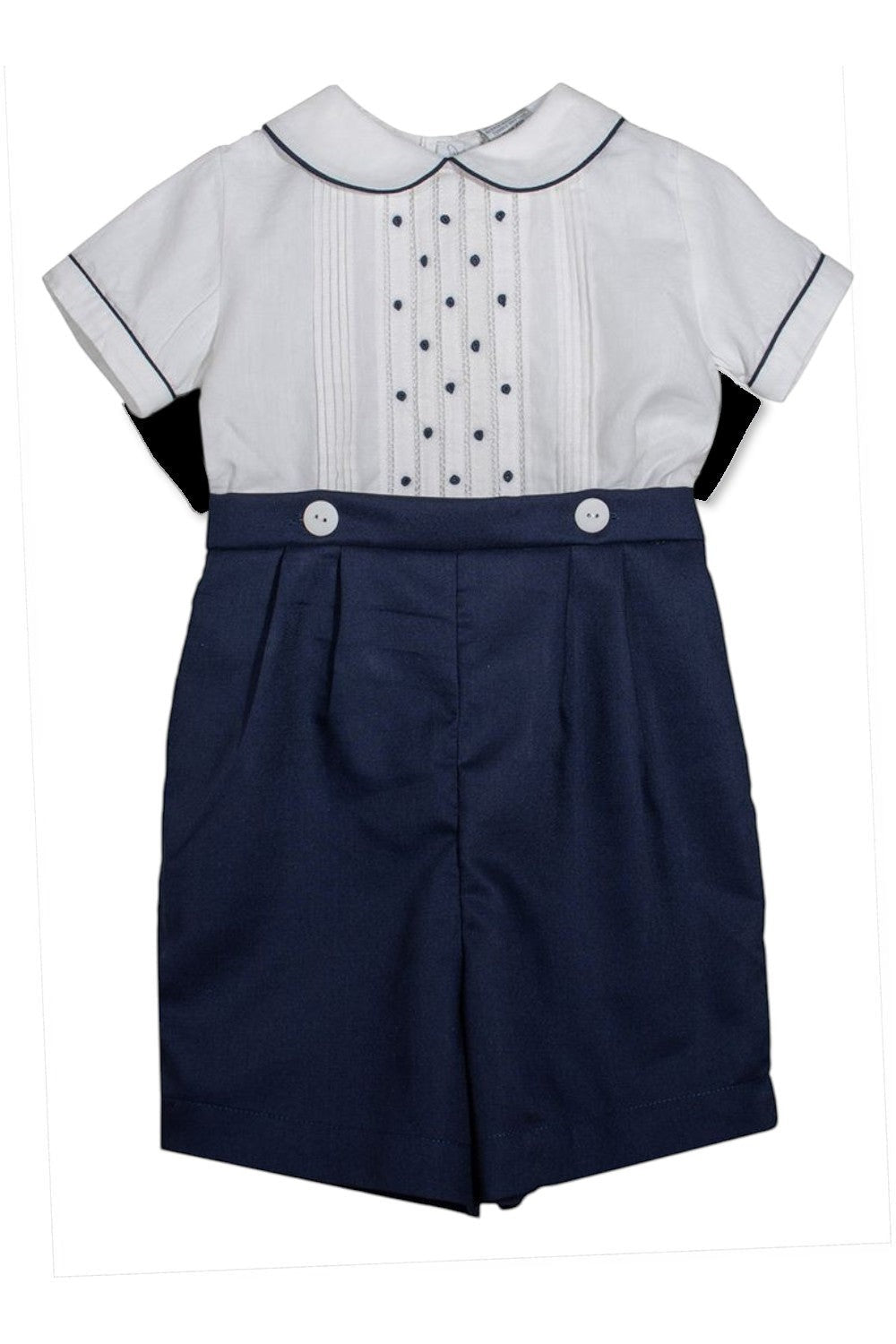 Carriage Boutique navy blue shorts with white buttons and a white short-sleeved shirt with pintucks and navy dots.