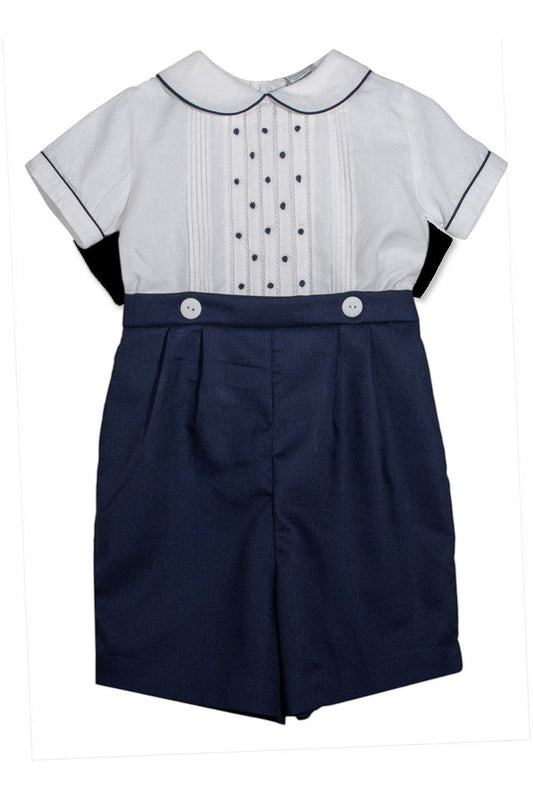 Carriage Boutique navy blue shorts with white buttons and a white short-sleeved shirt with pintucks and navy dots.