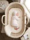 Carriage Boutique newborn baby sleeping in a vintage bassinet wearing a cream and blush pink striped knit legging set