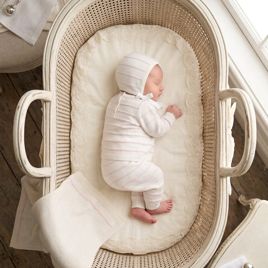 Carriage Boutique newborn set in cream knit with blush pink stripes, including a long-sleeve top, leggings, and hat.