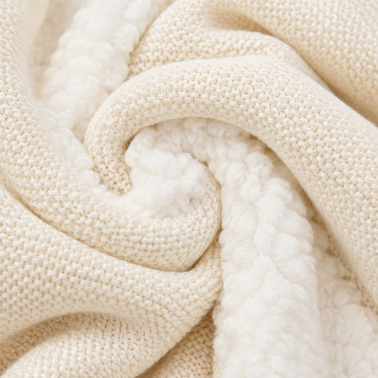 Close-up of Carriage Boutique off-white knit cotton fabric with soft white sherpa lining for a baby jacket