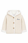 Carriage Boutique off-white knit cotton baby jacket with sherpa lining, hood, three front buttons, and Luca embroidery.