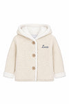 Carriage Boutique off-white knit cotton baby jacket with sherpa lining, hood, three buttons, and Luca monogram.