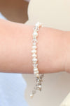 Carriage Boutique sterling silver baby cross bracelet with freshwater pearls and crystals on a child's wrist