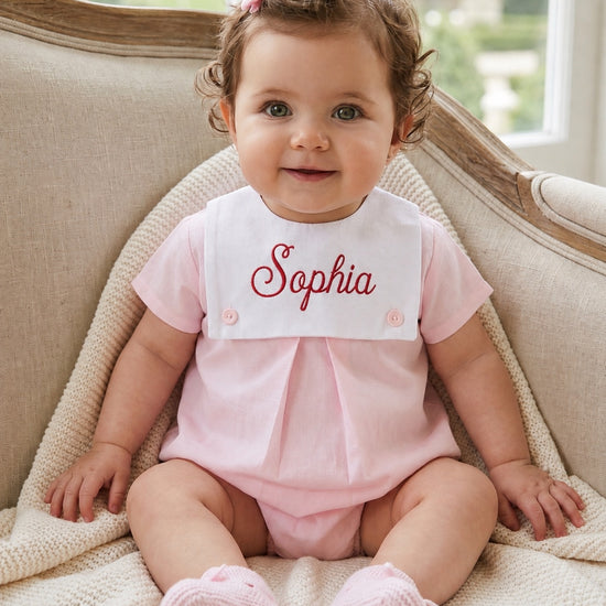 Carriage Boutique baby girl bubble romper in light pink cotton with a white personalized button bib and matching booties