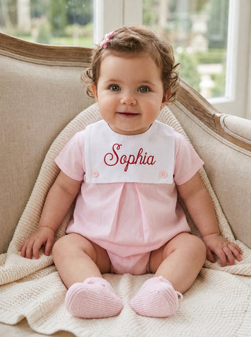 Carriage Boutique baby girl bubble romper in light pink cotton with a white personalized button bib and matching booties