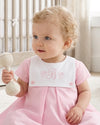 Carriage Boutique personalized baby girl dress in pink and white cotton with a monogrammed button bib