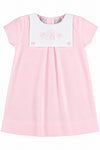Carriage Boutique personalized baby girl dress in light pink cotton with a white button bib and monogram embroidery.