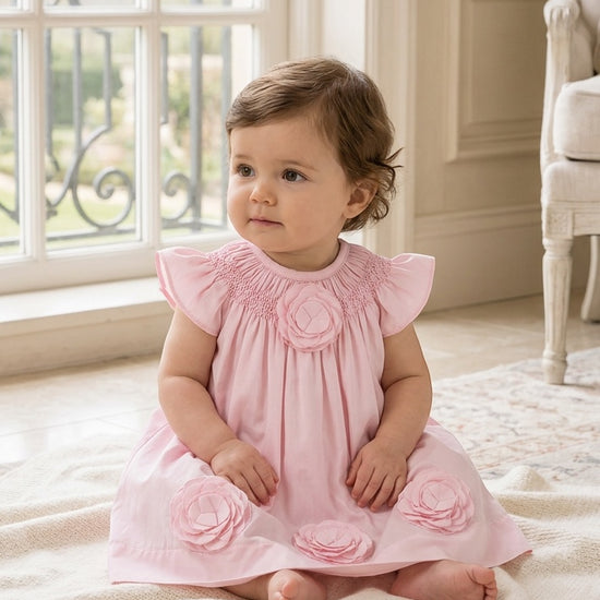 Carriage Boutique baby girl dress in classic pink with smocked bodice and delicate cut-out flower appliqués