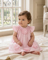 Carriage Boutique baby girl dress in classic pink with smocked bodice and delicate cut-out flower appliqués