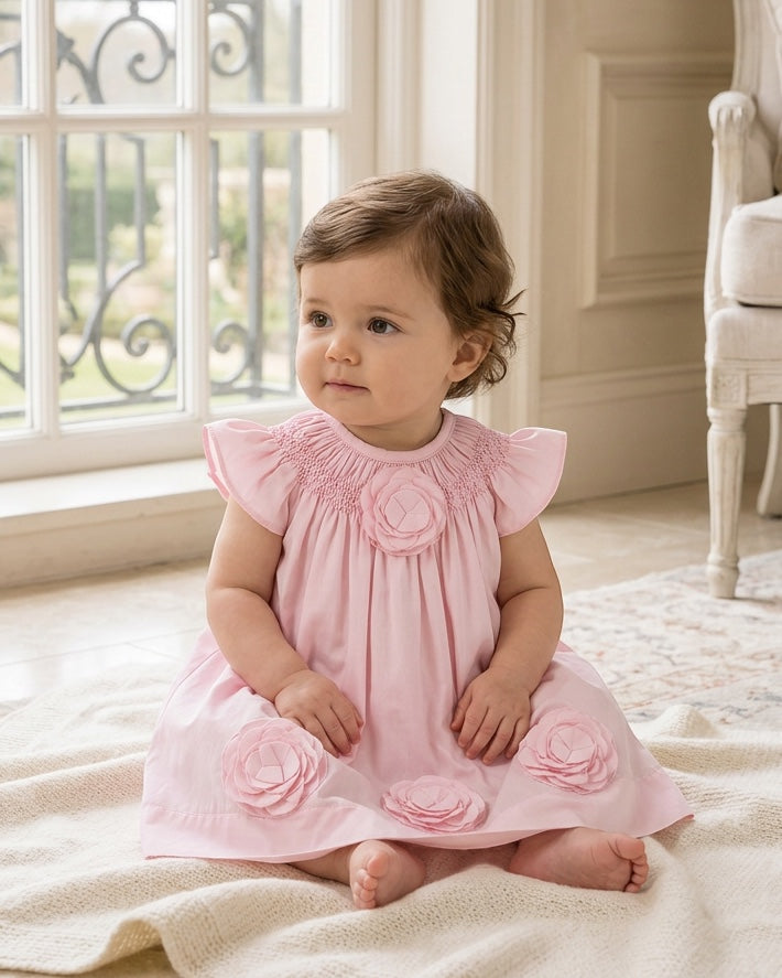 Carriage Boutique baby girl dress in classic pink with smocked bodice and delicate cut-out flower appliqués
