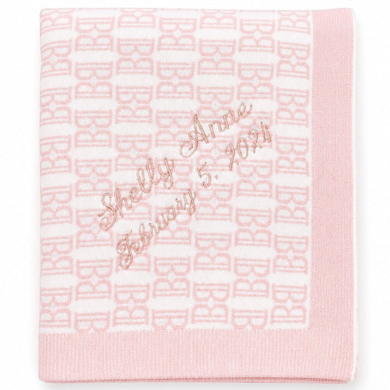 Carriage Boutique pink and white cotton baby blanket with custom embroidered name and date in a soft knit pattern.