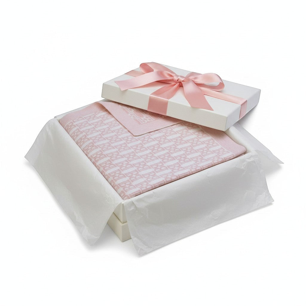 Carriage Boutique pink cotton baby blanket with knit logo pattern in a white gift box with a satin ribbon