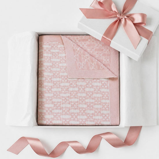 Carriage Boutique pink and white cotton baby blanket with monogram pattern in a gift box with a satin ribbon.
