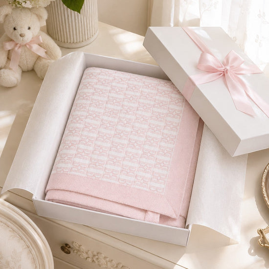 Carriage Boutique pink cotton baby blanket with classic knit pattern in a gift box with a satin ribbon.