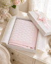 Carriage Boutique pink cotton baby blanket with classic knit pattern in a gift box with a satin ribbon.