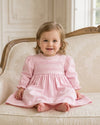 Carriage Boutique light pink cotton baby dress with long puffy sleeves, lace collar, and hand-embroidered pin tucks.