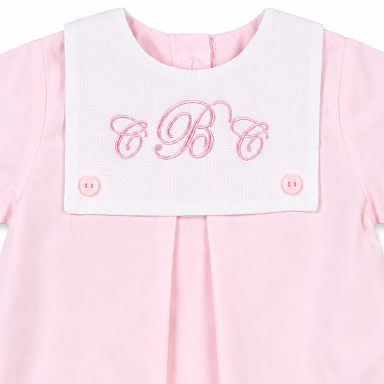 Carriage Boutique baby girl bubble romper in light pink cotton with a white button bib and pink monogram embroidery