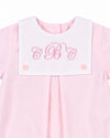 Carriage Boutique baby girl bubble romper in light pink cotton with a white button bib and pink monogram embroidery