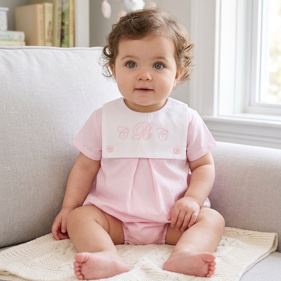 Carriage Boutique baby girl bubble romper in light pink cotton with a white button bib and custom pink embroidery.