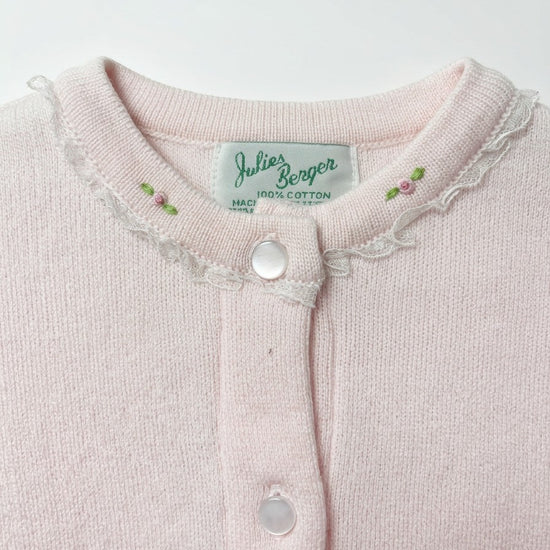 Carriage Boutique pink cotton cardigan featuring delicate lace trim and embroidered rosebud details at the crew neck.