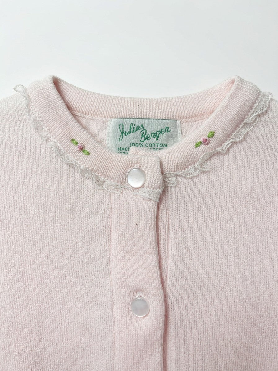 Carriage Boutique pink cotton cardigan featuring delicate lace trim and embroidered rosebud details at the crew neck.