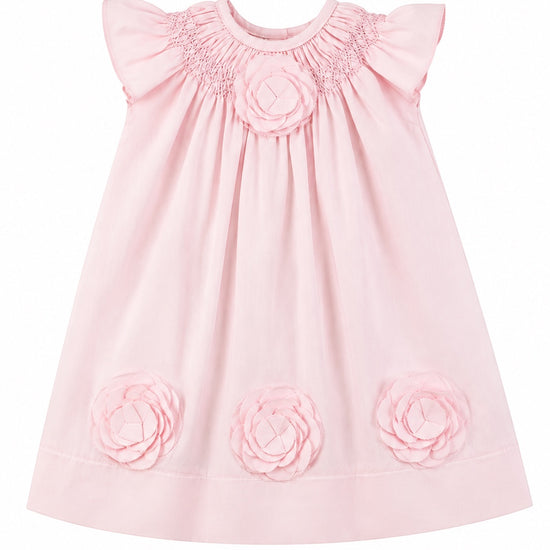 Carriage Boutique baby girl dress in classic pink featuring delicate cut-out flower appliqués and smocked neckline.