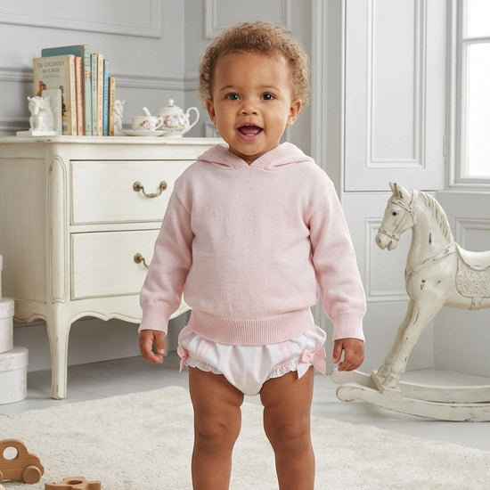 Carriage Boutique baby girl wearing a soft pastel pink cotton knit hooded sweater with white ruffled bloomers