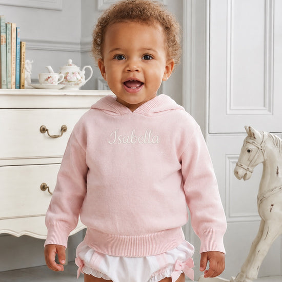 Carriage Boutique baby girl wearing a soft pink cotton knit hooded sweater with personalized embroidery