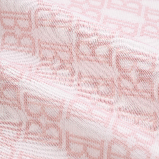 Carriage Boutique soft pink cotton baby blanket with a classic knit monogram B pattern for a cozy nursery.