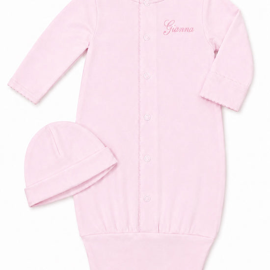 Carriage Boutique pink newborn sleep sack with matching hat, featuring scalloped cuffs and custom name embroidery.
